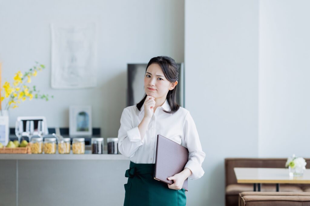 飲食店でデータ管理に悩む若い女性のスタッフ